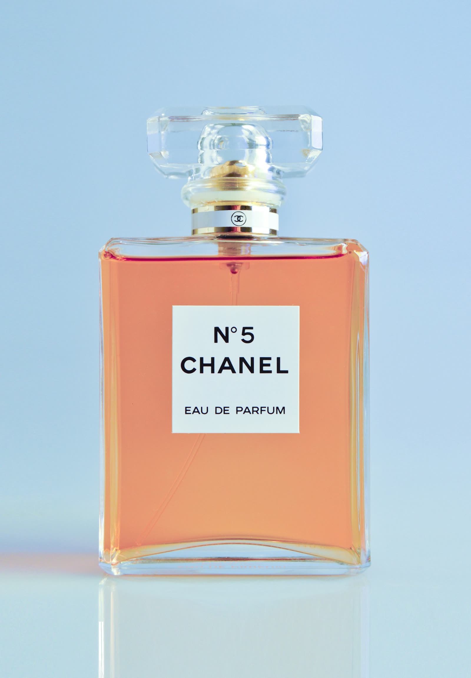 Clear rectangular glass cologne bottle with a pale liquid