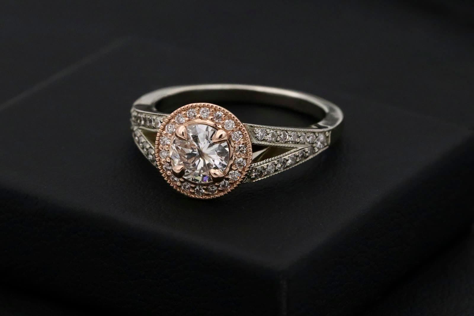 Gold-tone ring with a single round center stone on textured fabric