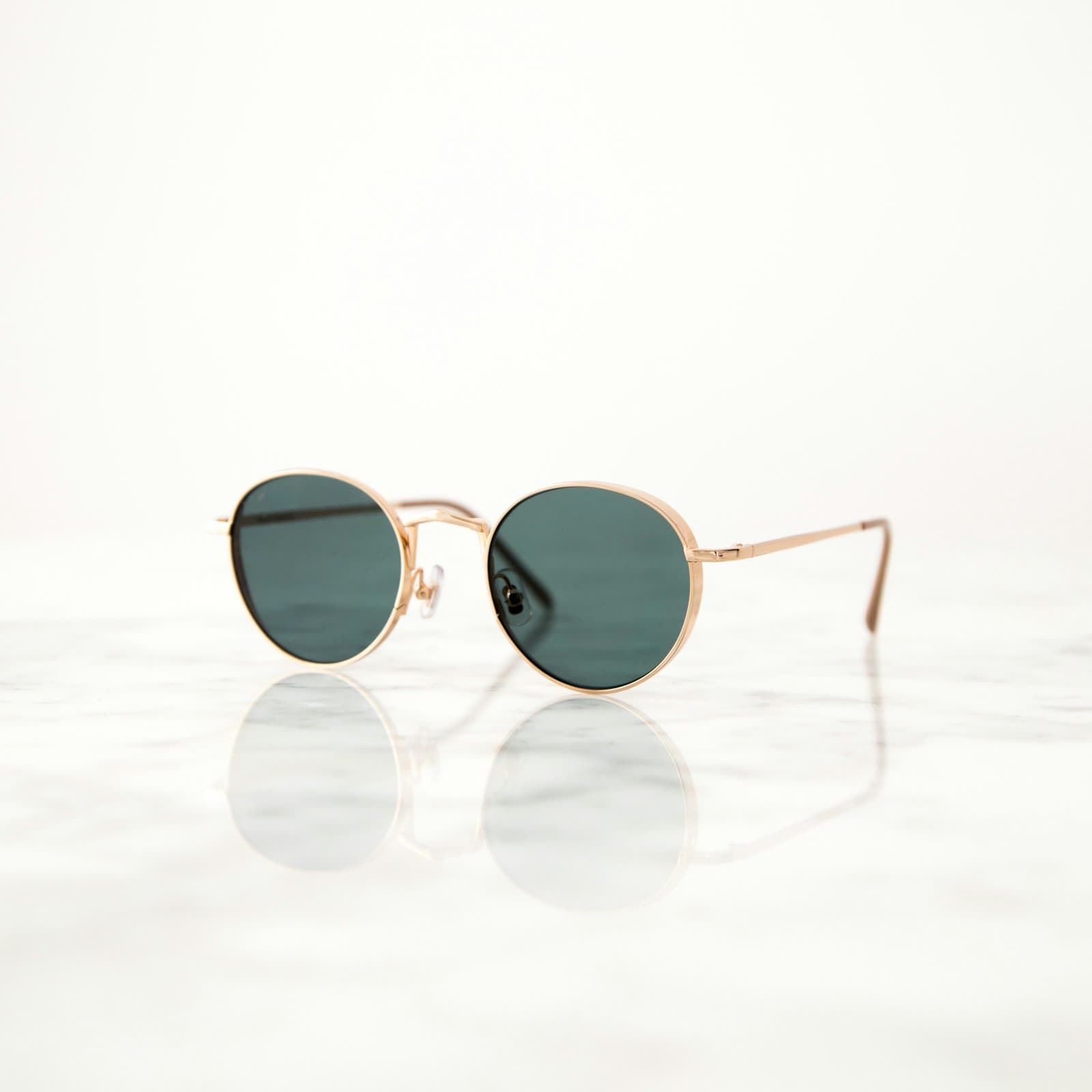 Dark lens sunglasses resting on a pale surface