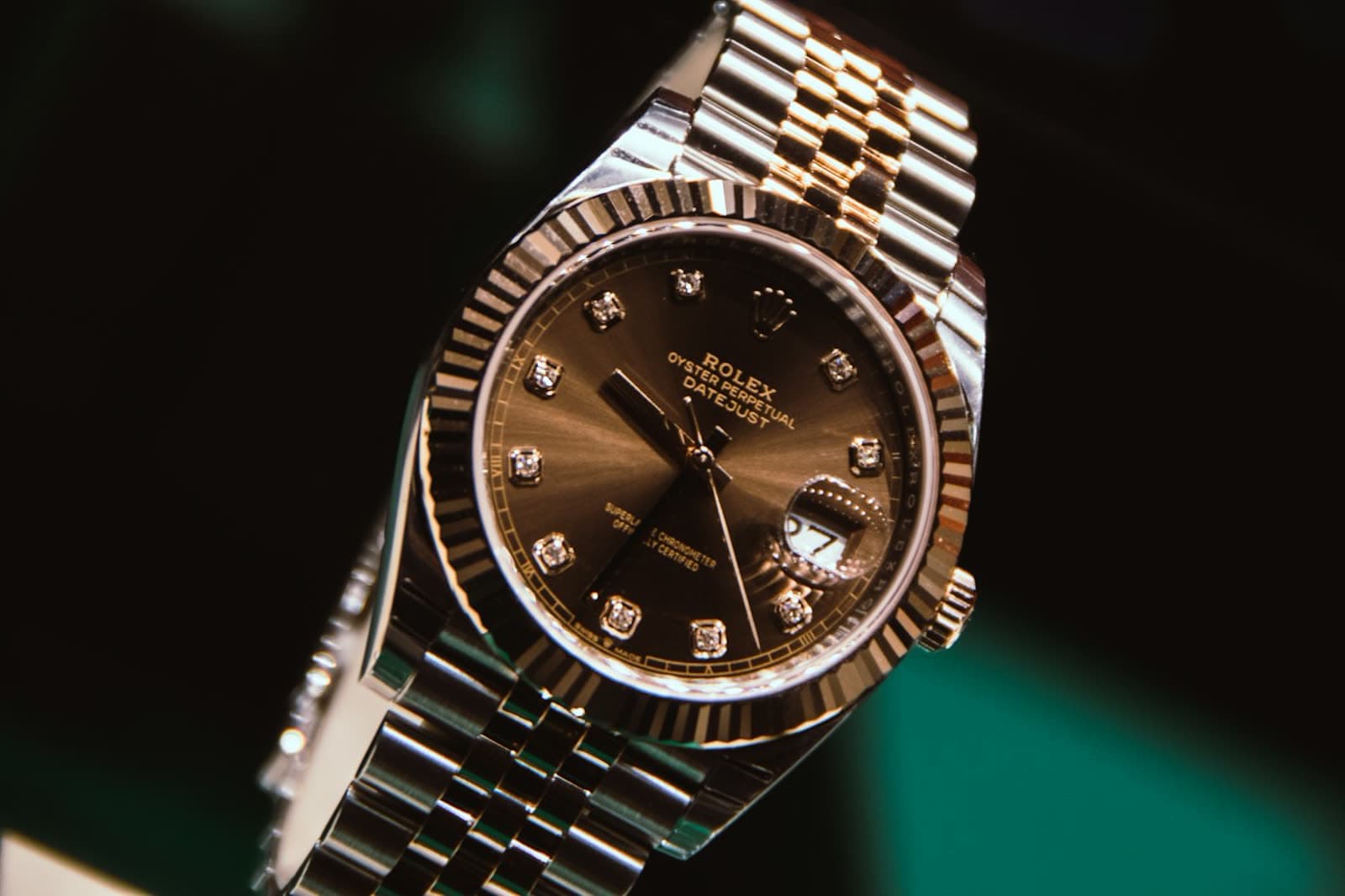 Gold-tone dress watch with a brown leather strap on a neutral surface