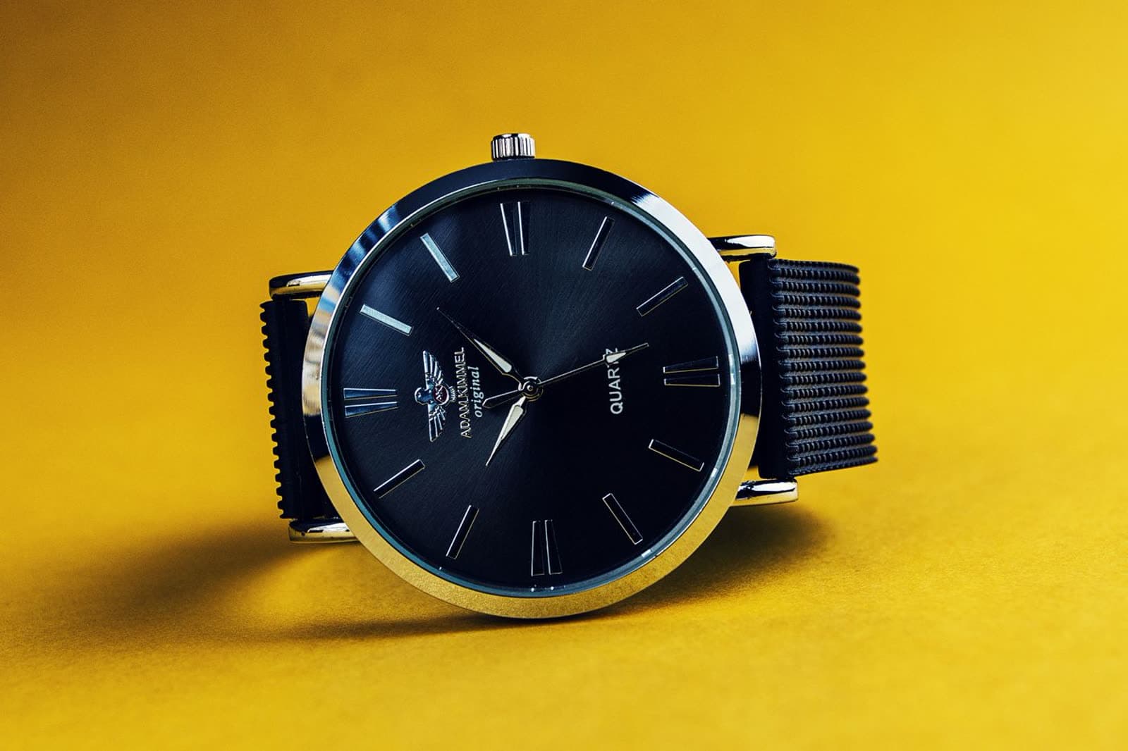 Analog watch with a brown leather strap on pale stone