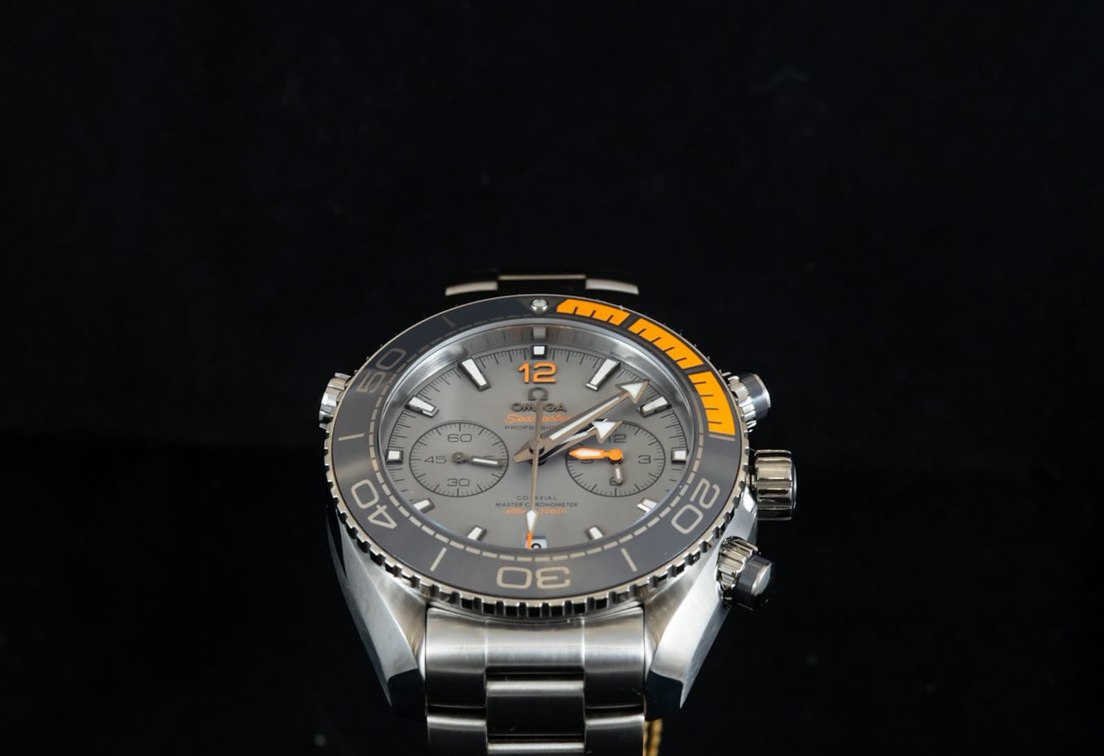 Macro of a round watch dial with applied markers and dauphine hands