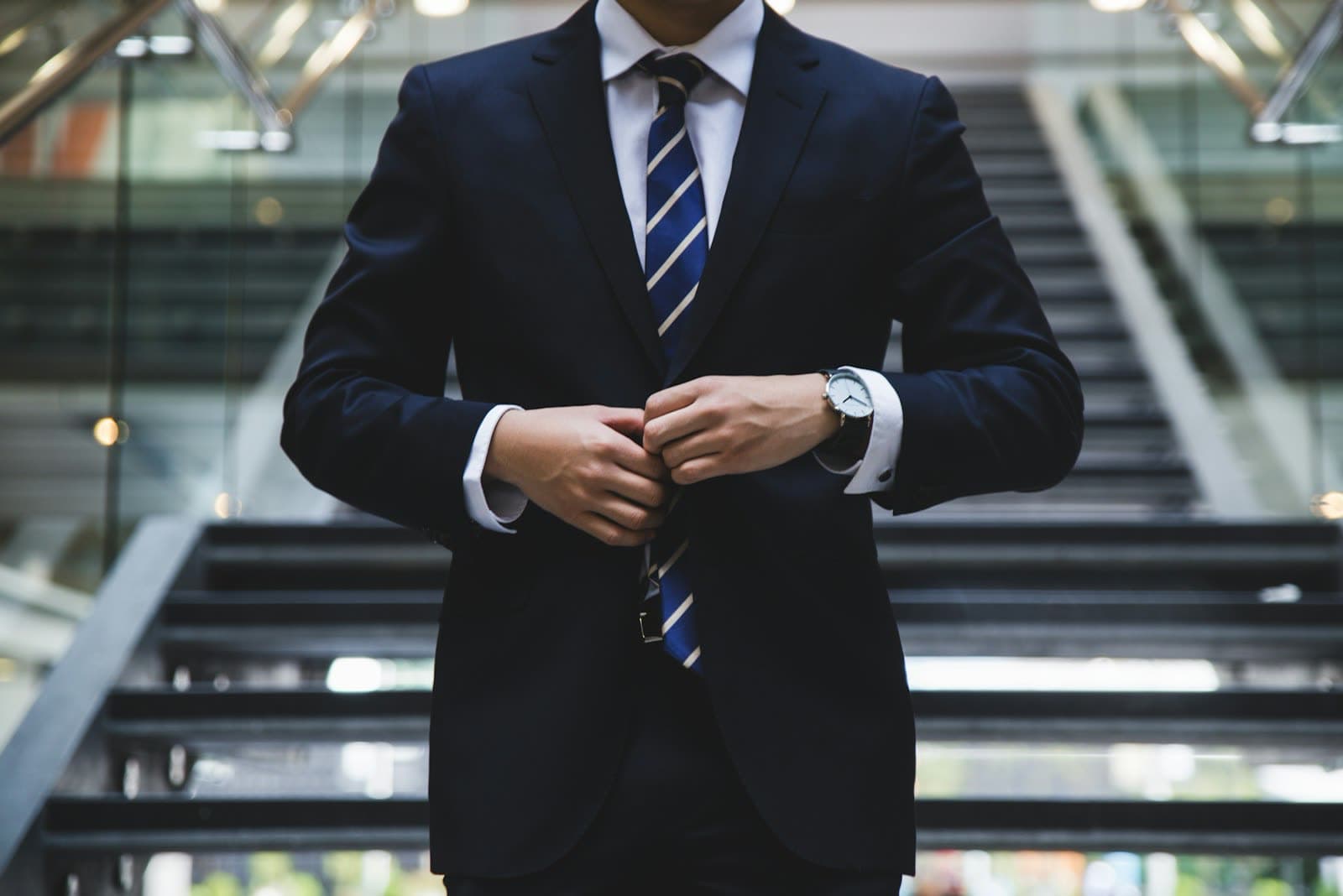 Man walking in a dark suit, seen from the side